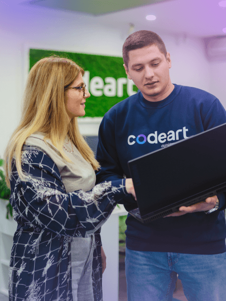 A man and woman looking at a laptop, discussing or collaborating on a task together
