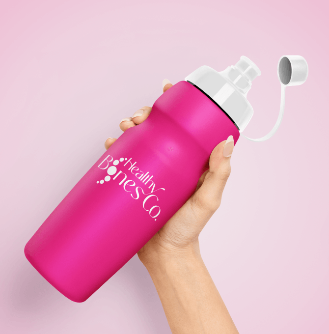 A pink water bottle featuring the Healthy Bones Co. logo.