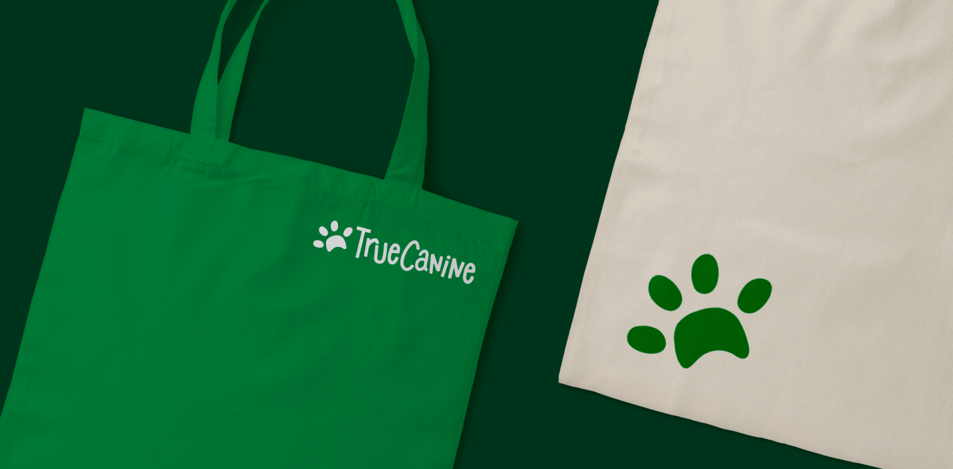 Green tote bag with the logo of True Canine.