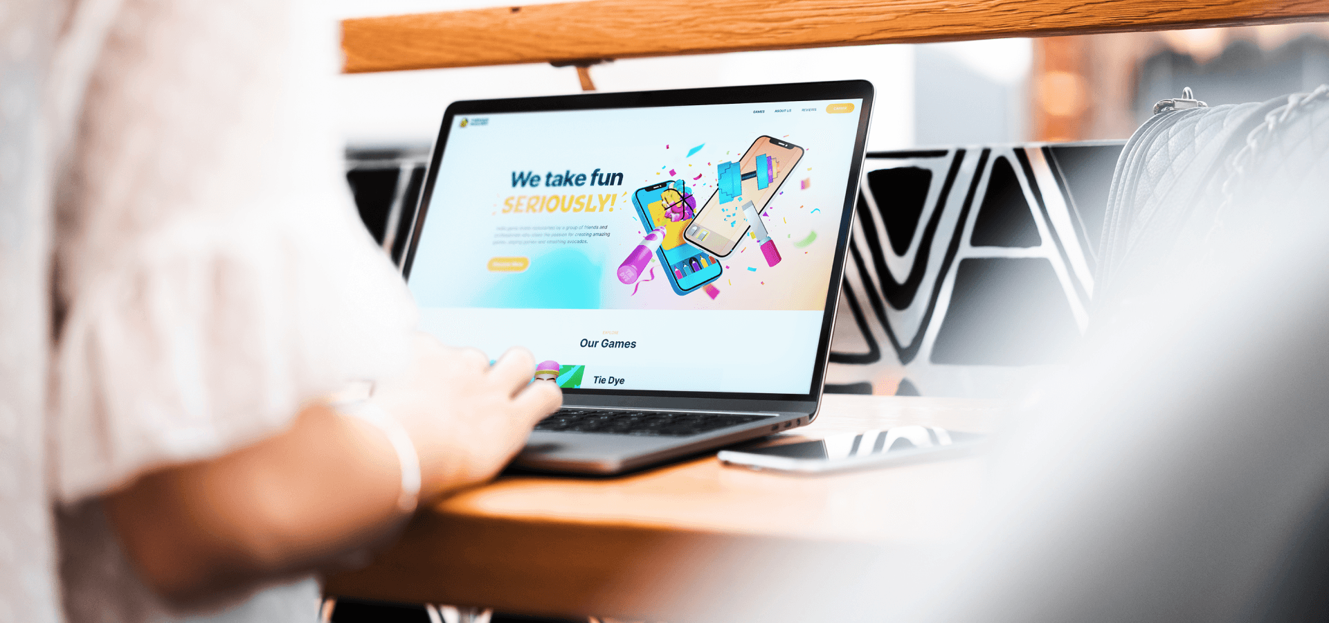 A person in front of a desk that has a laptop on that showcases Furious Avocado website.