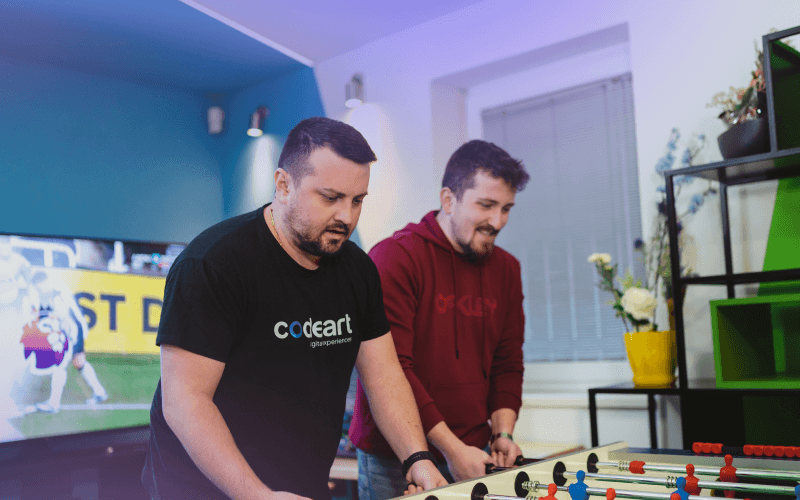 Two guys having fun playing foosball